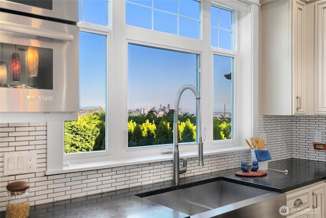 3048 39th Ave W, Seattle, WA 98199 - interior details with oven, decorative backsplash, a sink, and white cabinetry