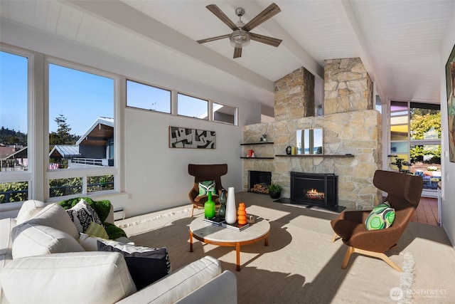 living room featuring a ceiling fan, beam ceiling, a wealth of natural light, and a fireplace