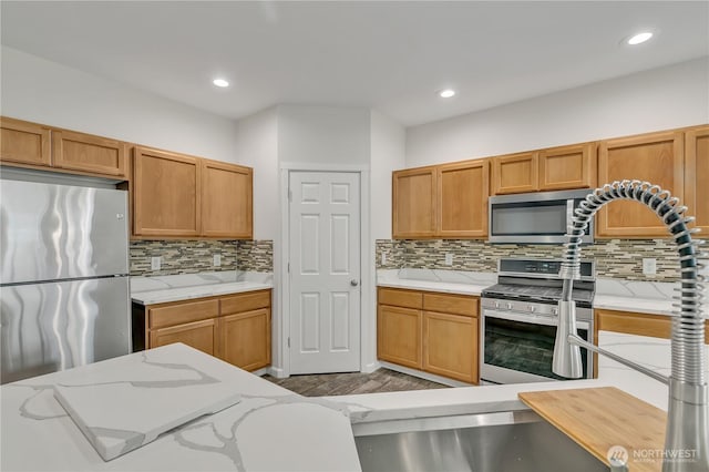 24204 SE 278th St, Maple Valley, WA 98038 - kitchen featuring stainless steel appliances, tasteful backsplash, wood finished floors, recessed lighting, and light stone countertops