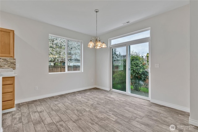 24204 SE 278th St, Maple Valley, WA 98038 - unfurnished dining area with a chandelier, light wood finished floors, and baseboards