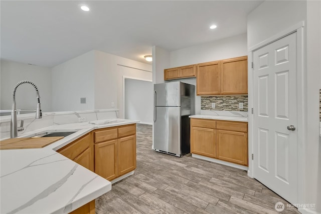 24204 SE 278th St, Maple Valley, WA 98038 - kitchen with freestanding refrigerator, a sink, light stone counters, decorative backsplash, and light wood-type flooring