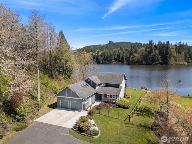 birds eye view of property featuring a forest view and a water view
