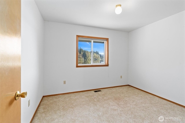 spare room with visible vents, carpet flooring, and baseboards