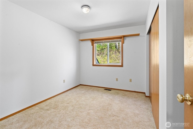 carpeted empty room with baseboards and visible vents
