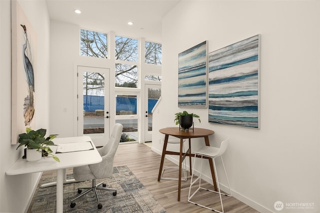 office with light wood-type flooring, recessed lighting, a high ceiling, french doors, and baseboards
