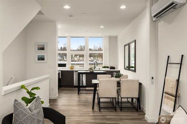 dining area featuring baseboards, recessed lighting, wood finished floors, and a wall mounted air conditioner