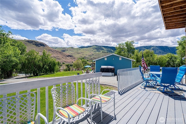 876 1st St, Chelan Falls, WA 98817 - wooden terrace featuring a mountain view, a lawn, an outdoor structure, and outdoor dining area