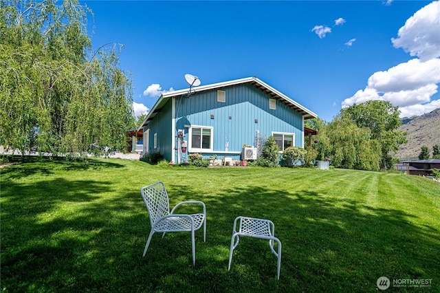 876 1st St, Chelan Falls, WA 98817 - rear view of property with board and batten siding, a yard, and a mountain view