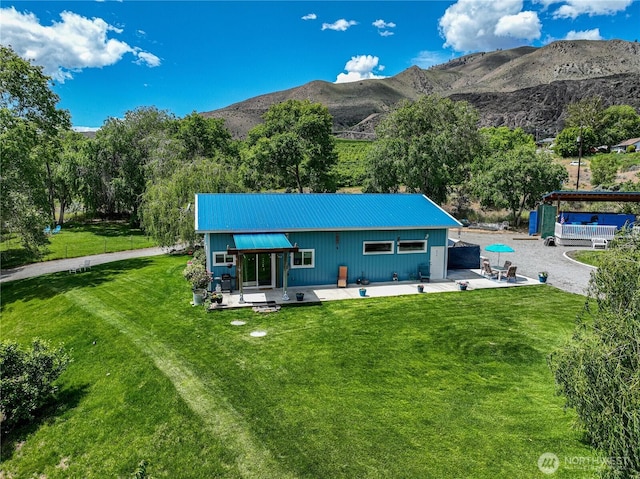 876 1st St, Chelan Falls, WA 98817 - rear view of property featuring a patio, metal roof, a lawn, and a mountain view