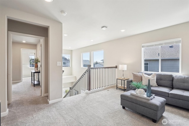 carpeted living area featuring baseboards and recessed lighting