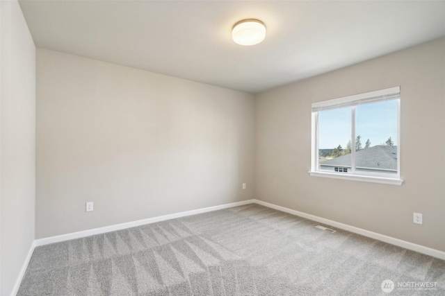 unfurnished room with carpet floors, baseboards, and visible vents