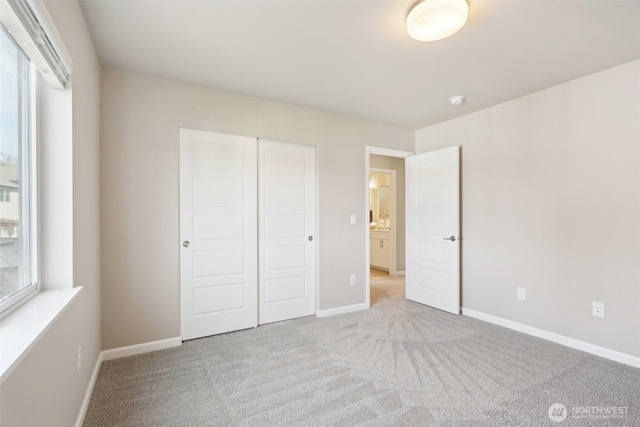 unfurnished bedroom featuring carpet floors, baseboards, and a closet