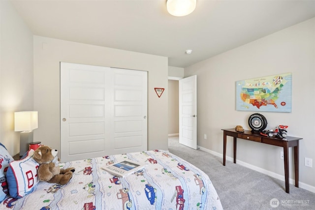 bedroom with a closet, baseboards, and carpet