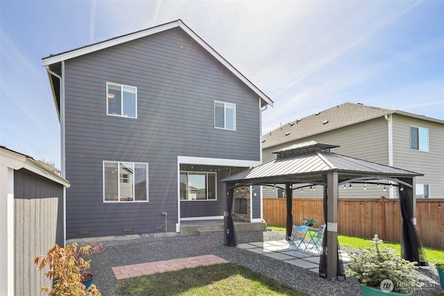 back of property with a patio area, a gazebo, and fence