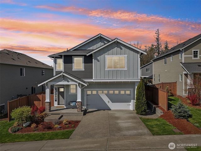 traditional-style home with concrete driveway, board and batten siding, fence, and an attached garage