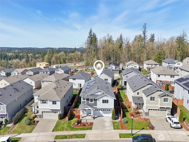 drone / aerial view featuring a residential view and a view of trees