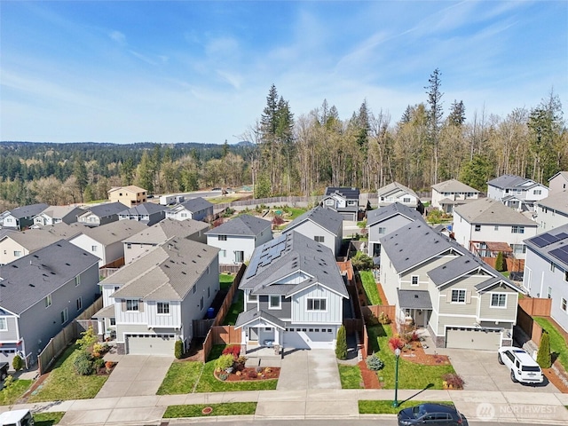 drone / aerial view featuring a forest view and a residential view