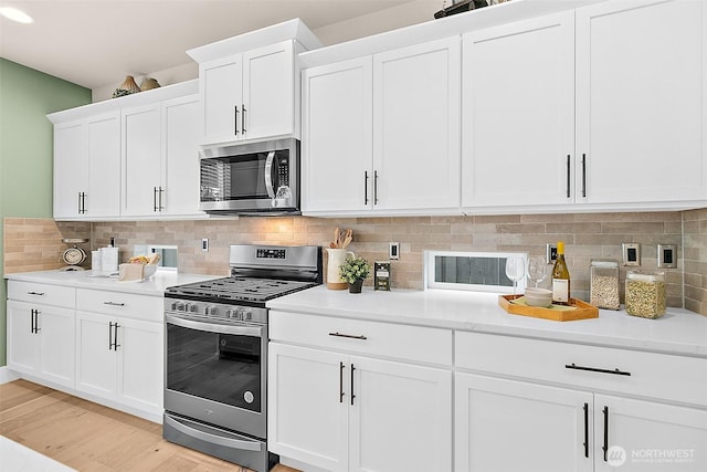 14232 SE 284th Pl, Kent, WA 98042 - kitchen with white cabinets, decorative backsplash, light countertops, and appliances with stainless steel finishes