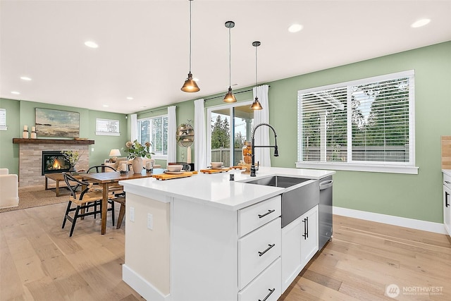 14232 SE 284th Pl, Kent, WA 98042 - kitchen featuring recessed lighting, light wood-type flooring, a tiled fireplace, and a sink