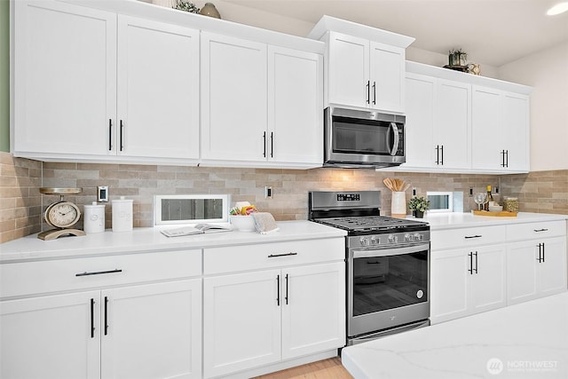14232 SE 284th Pl, Kent, WA 98042 - kitchen featuring white cabinets, stainless steel appliances, light wood-style flooring, backsplash, and light stone countertops