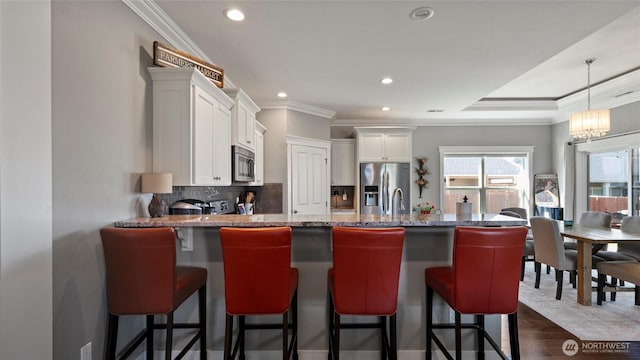 131 NW Blalock Dr, College Place, WA 99324 - kitchen with a peninsula, crown molding, white cabinets, decorative backsplash, and appliances with stainless steel finishes