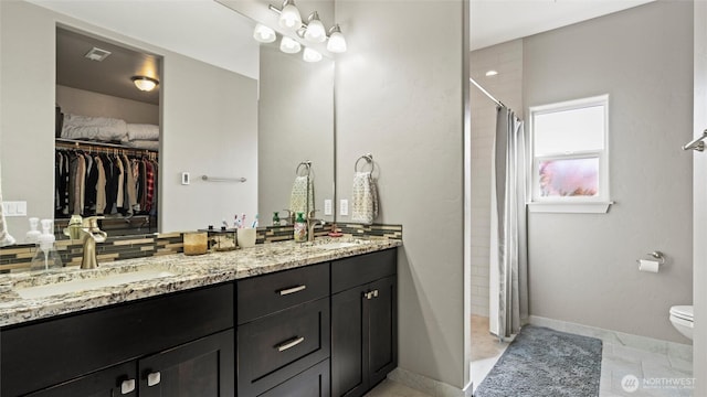 131 NW Blalock Dr, College Place, WA 99324 - bathroom with toilet, a sink, a walk in closet, a stall shower, and double vanity