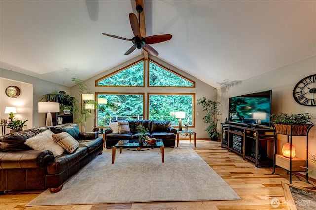living room featuring ceiling fan, light wood-style floors, and lofted ceiling