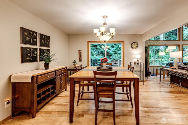 dining space with a notable chandelier and light wood-type flooring