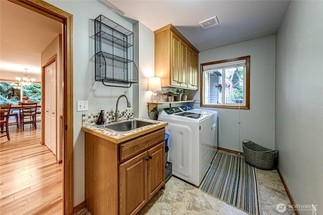 laundry room with independent washer and dryer, a healthy amount of sunlight, a sink, and cabinet space