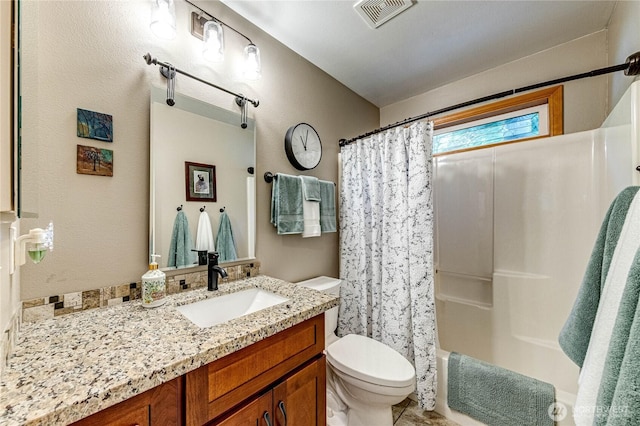full bath with vanity, visible vents, toilet, shower / tub combo with curtain, and a textured wall