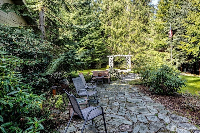 view of patio / terrace with a view of trees and outdoor dining area