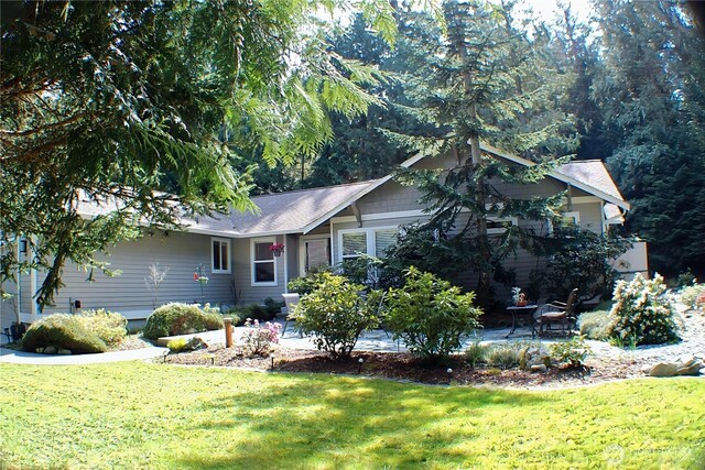 view of front of home with a patio and a front lawn
