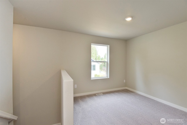 empty room with visible vents, baseboards, and carpet