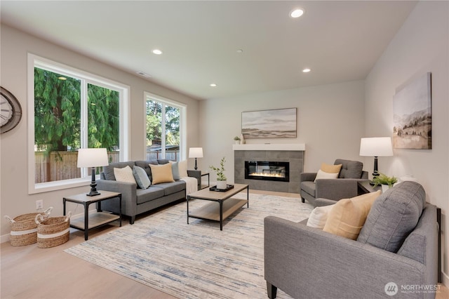 living area featuring visible vents, baseboards, recessed lighting, wood finished floors, and a fireplace