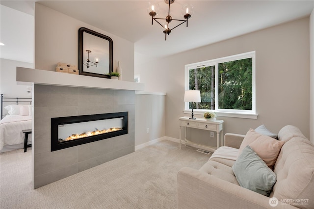carpeted living area featuring a chandelier, a tiled fireplace, visible vents, and baseboards