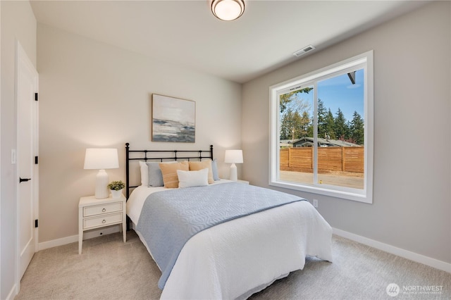 bedroom with visible vents, baseboards, and light carpet