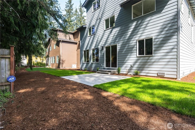 back of house with a yard and a patio