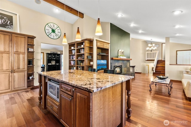24264 133rd Ave SE, Kent, WA 98042 - kitchen featuring a kitchen bar, stainless steel microwave, open shelves, and wood finished floors