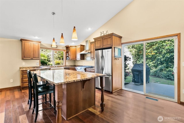 24264 133rd Ave SE, Kent, WA 98042 - kitchen with dark wood finished floors, light stone counters, stainless steel appliances, visible vents, and wall chimney exhaust hood