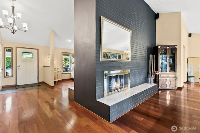 24264 133rd Ave SE, Kent, WA 98042 - foyer featuring baseboards, a notable chandelier, high vaulted ceiling, wood finished floors, and a fireplace