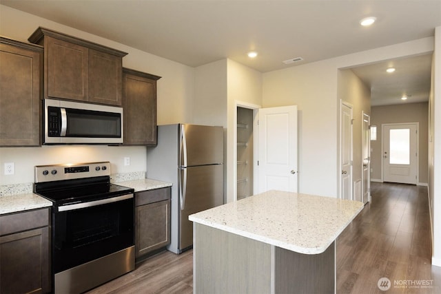 2306 158th Street Ct E, Tacoma, WA 98445 - kitchen featuring light stone counters, dark brown cabinets, visible vents, stainless steel appliances, and wood finished floors