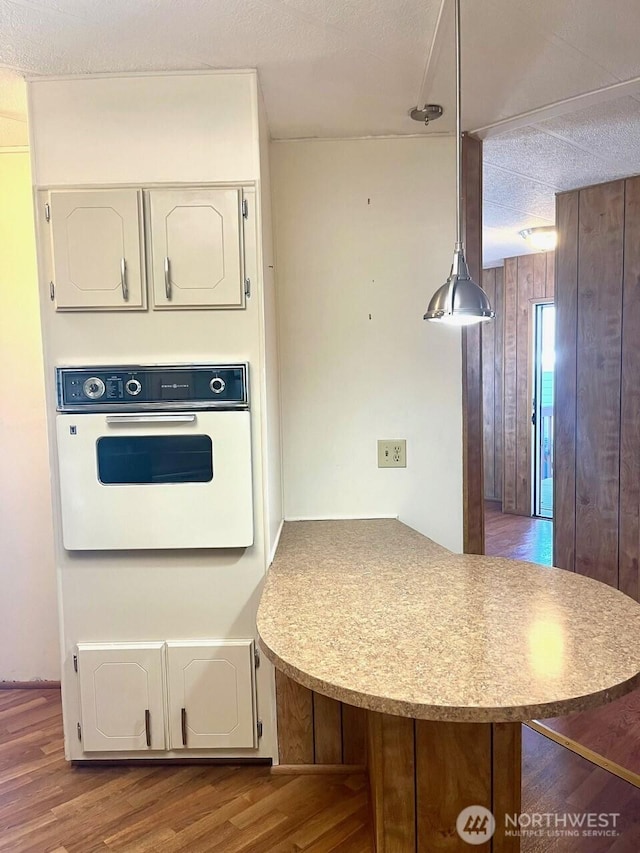 815 124th St SW Unit 144, Everett, WA 98204 - kitchen with wood walls, a peninsula, white oven, and wood finished floors