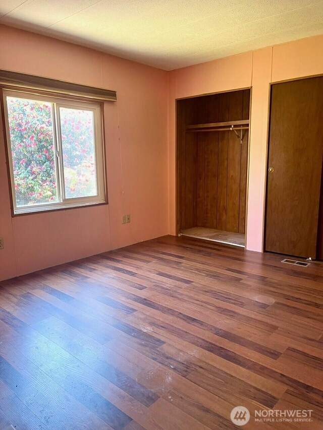 815 124th St SW Unit 144, Everett, WA 98204 - unfurnished bedroom with wood finished floors, visible vents, and two closets