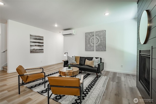 709 E 5th St, Nooksack, WA 98276 - living room featuring an AC wall unit, baseboards, recessed lighting, and light wood finished floors