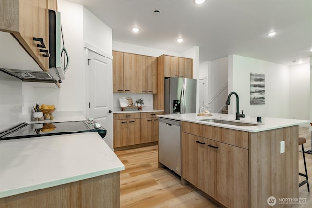709 E 5th St, Nooksack, WA 98276 - kitchen featuring a kitchen island with sink, light wood-style floors, modern cabinets, a sink, and appliances with stainless steel finishes
