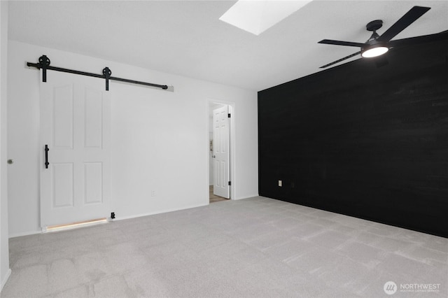 5350 Aspinwall Ct NW, Olympia, WA 98502 - empty room featuring carpet floors, a skylight, a barn door, and ceiling fan