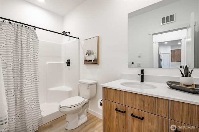 710 E 5th St, Nooksack, WA 98276 - full bath featuring visible vents, vanity, wood finished floors, curtained shower, and toilet