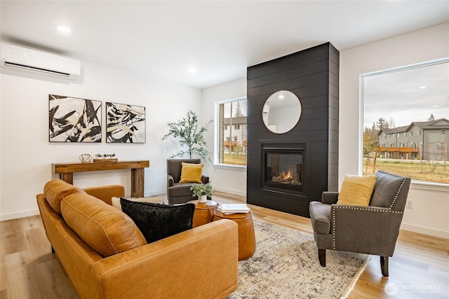 710 E 5th St, Nooksack, WA 98276 - living area featuring a large fireplace, a wall mounted AC, wood finished floors, baseboards, and recessed lighting