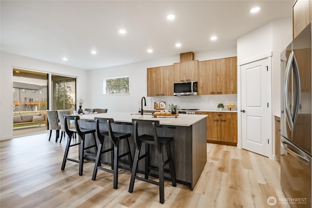 710 E 5th St, Nooksack, WA 98276 - kitchen featuring a breakfast bar, a kitchen island with sink, light countertops, stainless steel appliances, and modern cabinets