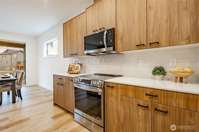 710 E 5th St, Nooksack, WA 98276 - kitchen featuring light countertops, decorative backsplash, light wood-style floors, and stainless steel appliances